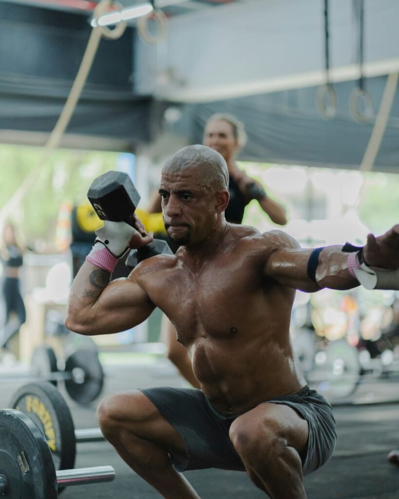 Athlete squatting with dumbbells in a home training space