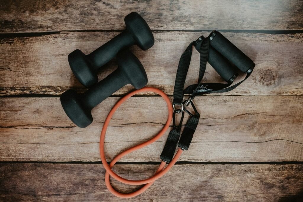 Dumbbells and resistance band on a wooden floor