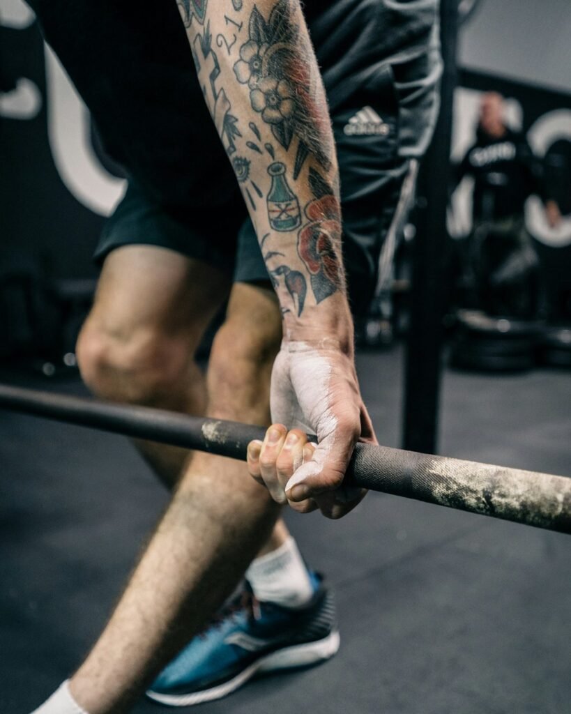 Close-up of chalked hands gripping a barbell